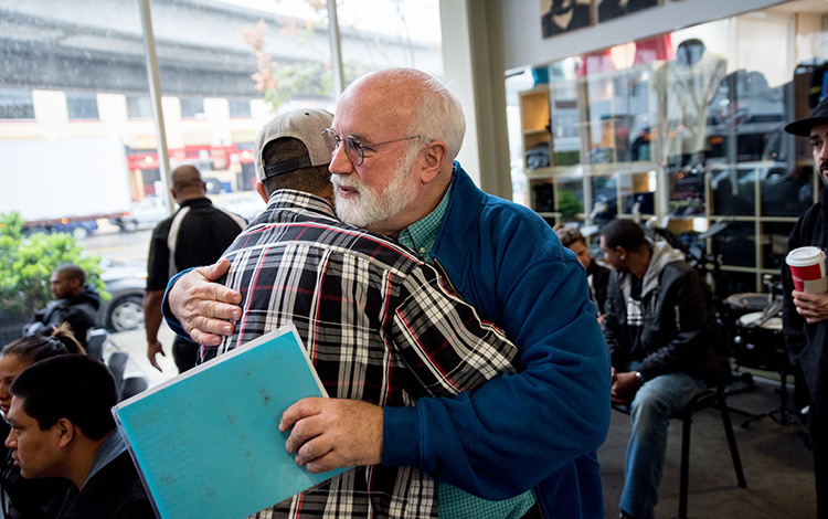 Father Greg Boyle embraces someone at Homeboy Industries. Father Greg Boyle embraces someone at Homeboy Industries.