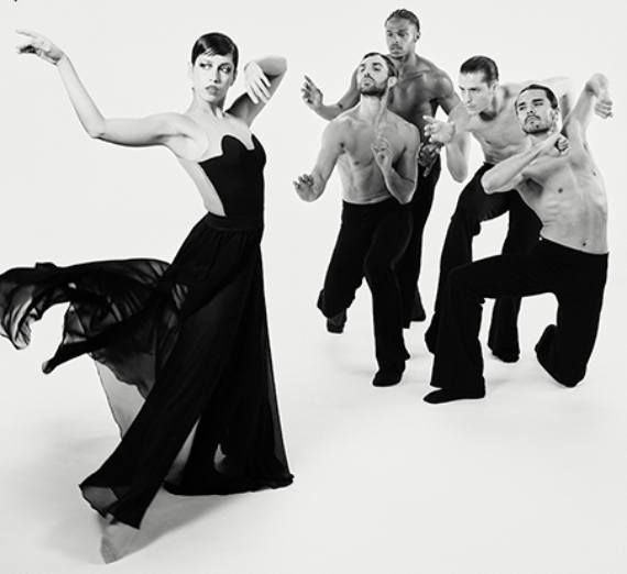 Dancers from Ballet Hispánico New York perform a dramatic moment from CARMEN.maquia on stage at the Myrtle Woldson Performing Arts Center. Dressed in minimalist black-and-white costumes, the performers strike dynamic, angular poses under focused stage lighting, conveying the intensity and passion of the reimagined ballet.