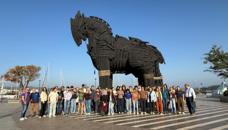 Group of Gonzaga University students and faculty visiting the ancient city of Troy in Turkey, standing in front of the iconic Trojan Horse replica during a history department study abroad trip.
