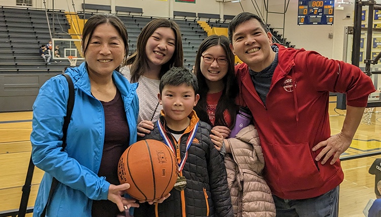 Jay Yang posing with family on basketball court Jay Yang posing with family on basketball court