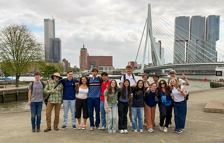 Many students stand at the Rotterdam skyline
