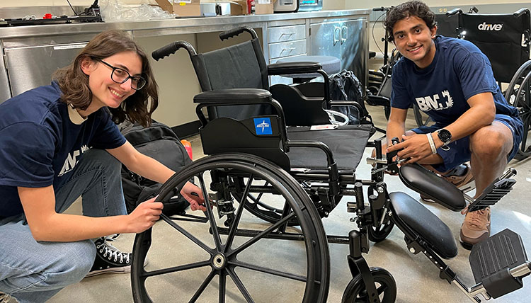 Two students assemble a manual wheelchair Two students assemble a manual wheelchair