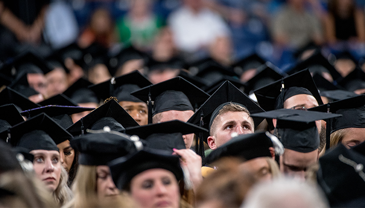 audience of graduates in black caps audience of graduates in black caps