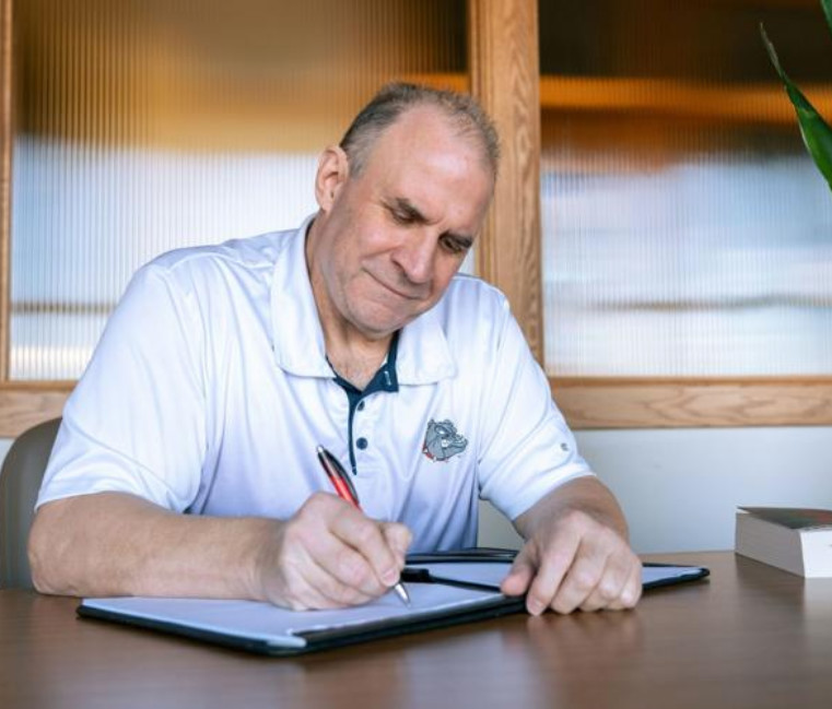 Vito DiMaio at a desk writing. Courtesy of Ash Elliot of the Gonzaga Bulletin Vito DiMaio at a desk writing. Courtesy of Ash Elliot of the Gonzaga Bulletin