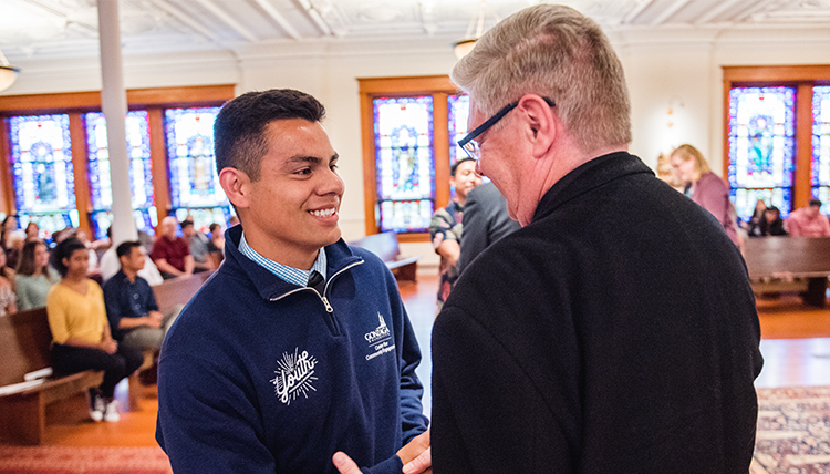 father pat lee congratulates student in chapel father pat lee congratulates student in chapel