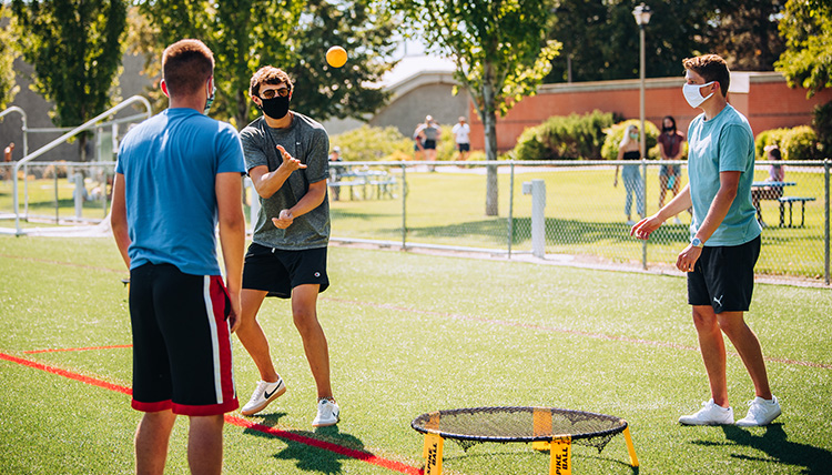A group of students play spike ball while wearing masks on Mulligan Field. A group of students play spike ball while wearing masks on Mulligan Field.