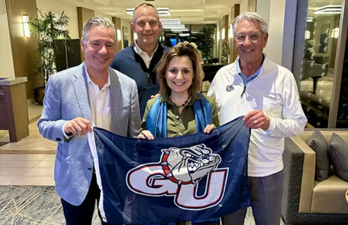 Group of GU President, Athletic Director and Trustees pose with GU flag Group of GU President, Athletic Director and Trustees pose with GU flag