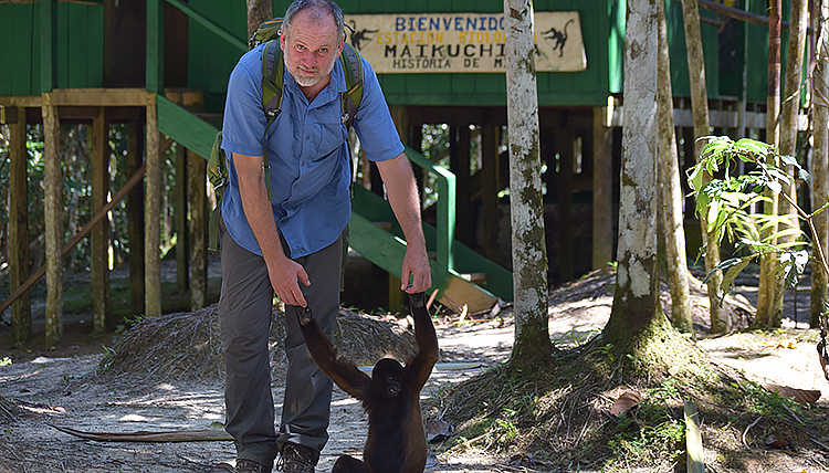 Associate Professor of Environmental Studies Dr. Greg Gordon poses for a photo with a monkey Associate Professor of Environmental Studies Dr. Greg Gordon poses for a photo with a monkey