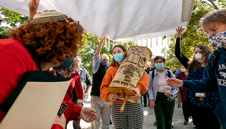 student carries the Torah under protection student carries the Torah under protection