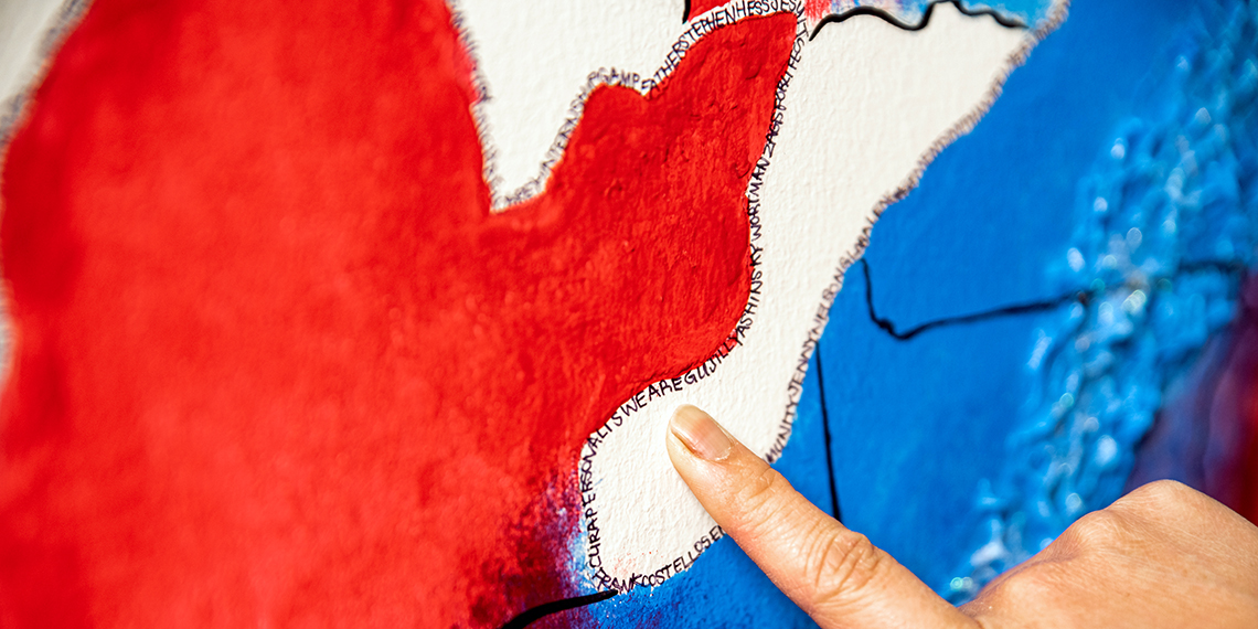 Cat Truong (’14) in front of the mural she created in Gonzaga's advancement office. (Photo by Zack Berlat)
