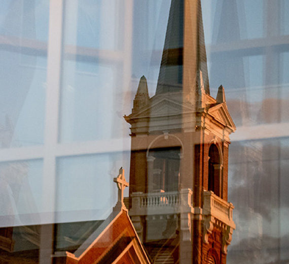 A reflection of St. Aloysius Church from a Jepson Center window