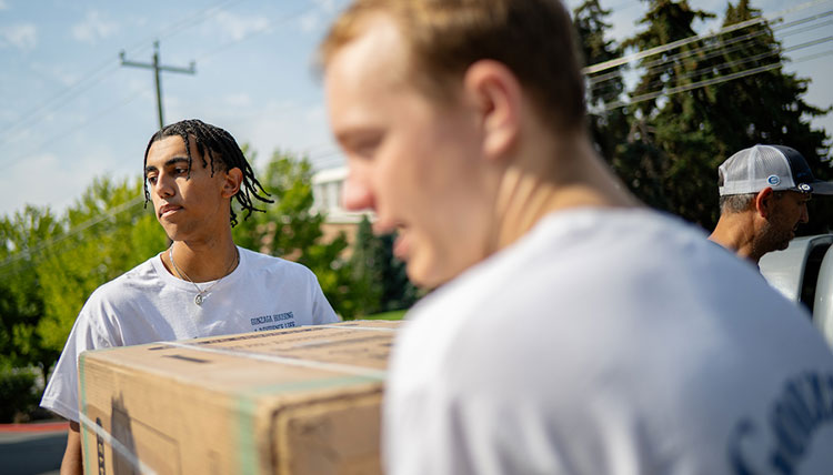 Two men carry a box Two men carry a box