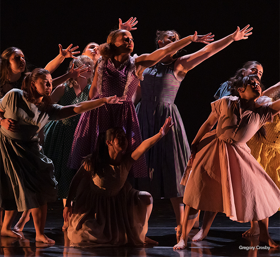 Dancers on stage moving in unison.