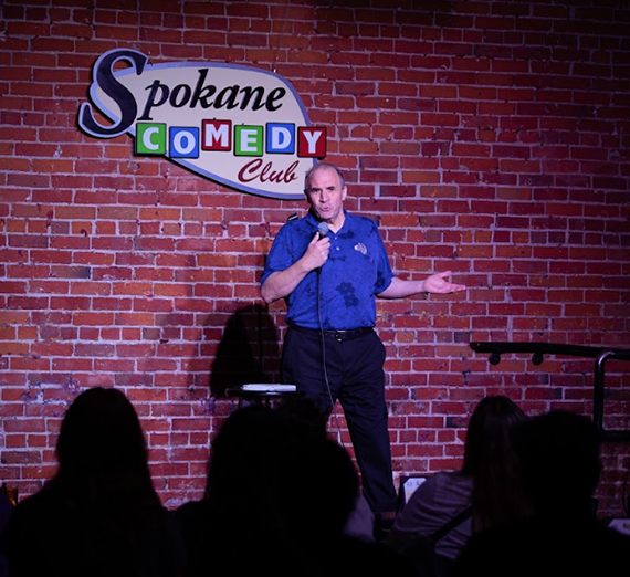 Man on stage doing stand up comedy.