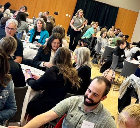 Attendees sitting at tables at a leadership training and development event