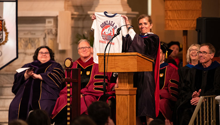 Interim Provist Mia Bertagnolli holds up a Gonzaga t-shirt as several faculty members look on Interim Provist Mia Bertagnolli holds up a Gonzaga t-shirt as several faculty members look on